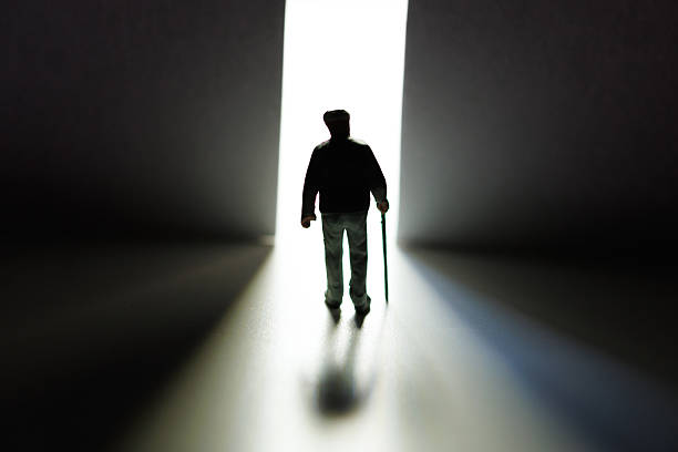 istock Old man walking away towards light through open door 2236051080