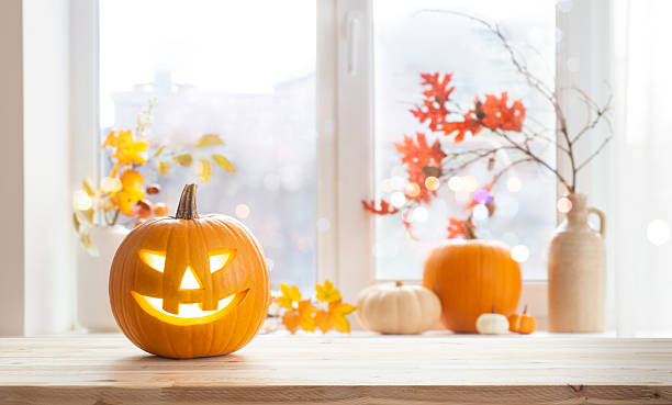 istock Orange jack o lantern pumpkin on wooden table with copy space over blurred window sill background with traditional Halloween house decoration 2236053034