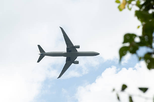 istock Airplane Flying Through the Sky Amidst Clouds and Trees in a Bright Atmosphere During Daytime 2236053758