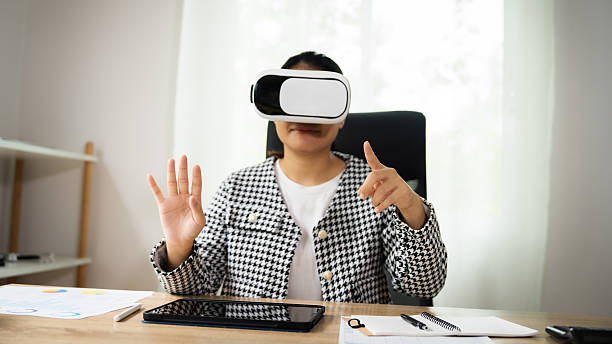 istock A woman wearing a black and white checkered jacket is playing a video game with a virtual reality headset on 2236053767