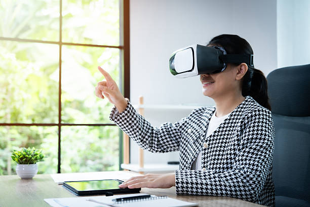 istock A woman wearing a black and white jacket is playing a video game with a virtual reality headset on 2236053768