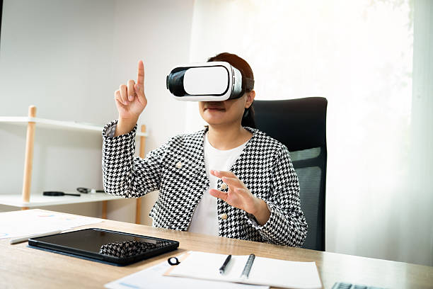 istock A woman wearing a black and white jacket is playing a video game with a pointer. She is pointing at the screen with her finger 2236053774