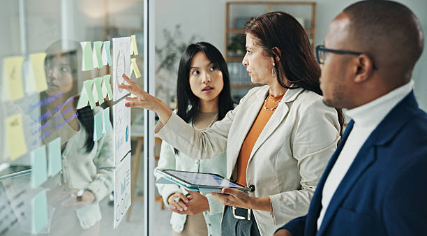 istock Team Collaboration at Glass Whiteboard in Modern Office Environment 2236059514