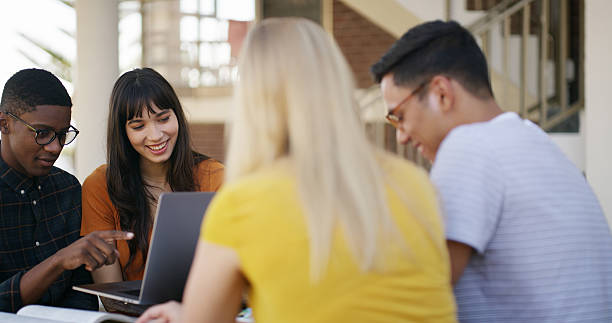 istock Laptop, teamwork and people in library with studying for college exam, test or assignment together. Computer, happy and students with education for assessment with group at university campus. 2236063115