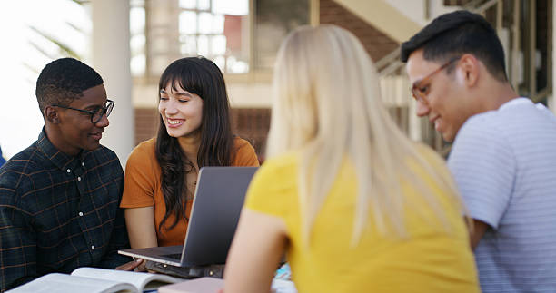 istock Laptop, group and people in library with studying for college exam, test or assignment together. Computer, happy and students with education for assessment with teamwork at university campus. 2236063140