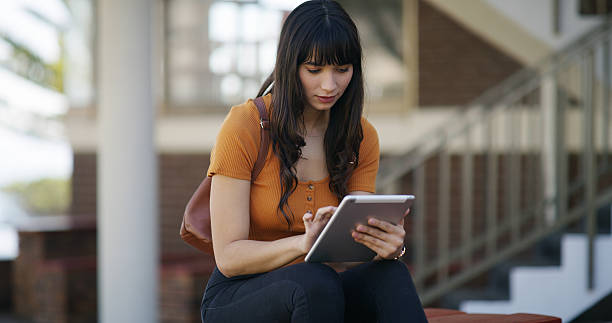istock Girl, student and online curriculum with tablet for network connection, study or course on campus. Female person, academic learner and scrolling with technology for higher education, learning or app 2236063162