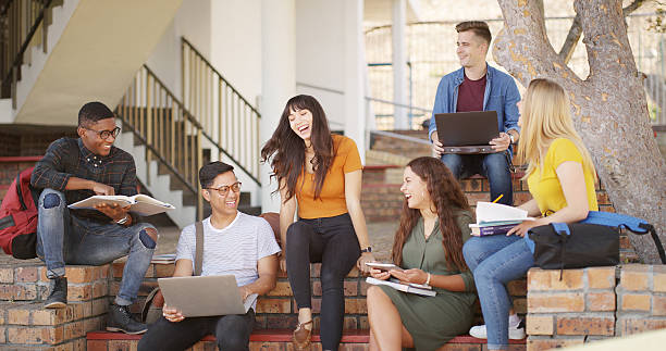 istock People, students and laugh with laptop at campus for education, research and group project. Friends, pc and textbook for learning, university scholarship and studying information for exam preparation 2236063164
