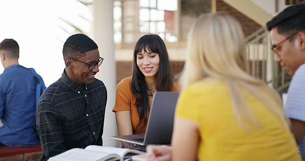 istock Happy people, students or laptop with research on campus for group project or assignment. College, friends and smile with computer or textbooks on break for study material or team assessment together 2236063175