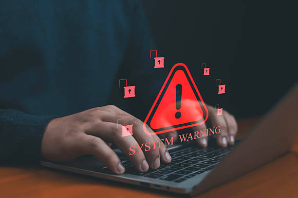 istock Hands typing on laptop with red system warning icon and unlocked padlock symbols, concept of cybersecurity breach, hacking risk, data theft, malware attack, and online information security threat. 2236064647
