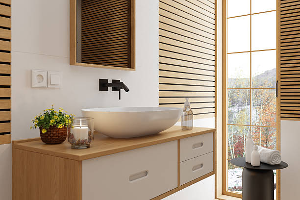 Shot of a clean bathroom vanity in a domestic bathroom.There's a soap dispenser on a sink and a clean new towel hanging nearby.
