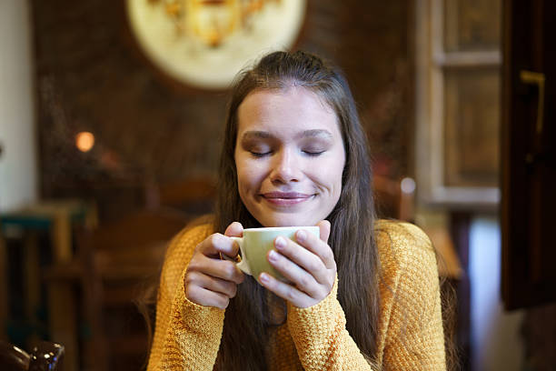 Joyful Moment A Woman Enjoying a Warm Beverage Inside a Cozy and Inviting Cafe Setting