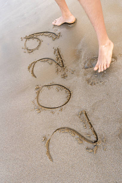 istock 2029 numbers written on sand. Feet top view 2236069437