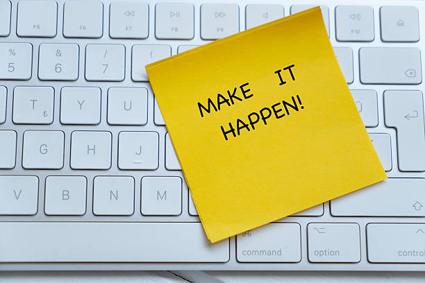 istock Yellow paper note with Make It Happen on part of keyboard 2236075106