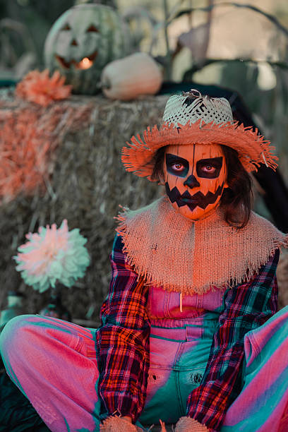 istock Scarecrow sitting in the orchard with Halloween decorations around it 2236079852