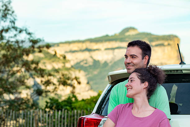 istock Couple Embracing by Their Car in a Forested Landscape 2236082965