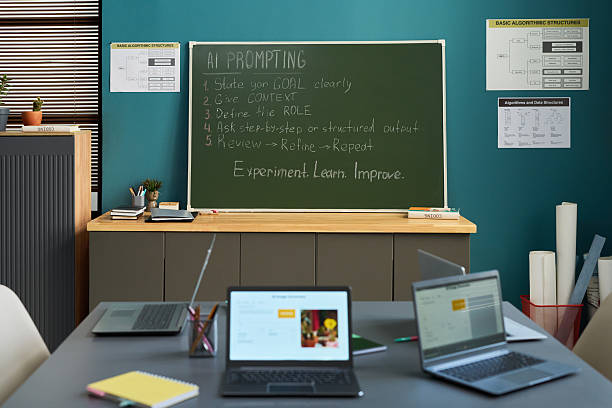 istock Classroom Showing Laptops on Table and Chalkboard Displaying AI Prompting Steps 2236085000