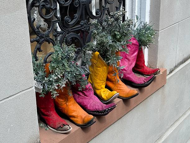 Bright colorful cowboy boots in a store window made to be used as planters in Savannah Georgia
