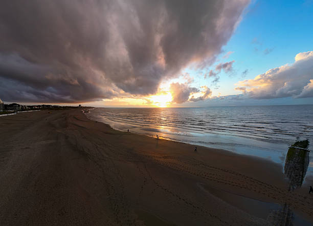 A breathtaking view of a beach sunset scene, showcasing vibrant colors and dynamic, artistic cloud formations