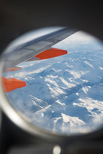 istock Snowy Alps Seen from Airplane Window with Wing in Frame 2236087970