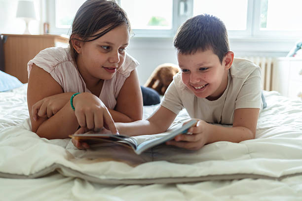 istock Boy, sister and reading book on sofa house for knowledge, bonding and learning literature, fantasy and language development. Family, girl and storytelling, education and information of child growth. 2236088061
