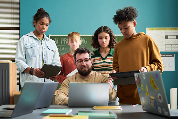 istock Caucasian Man Teaching Diverse Teenagers Using Digital Tablets 2236090059