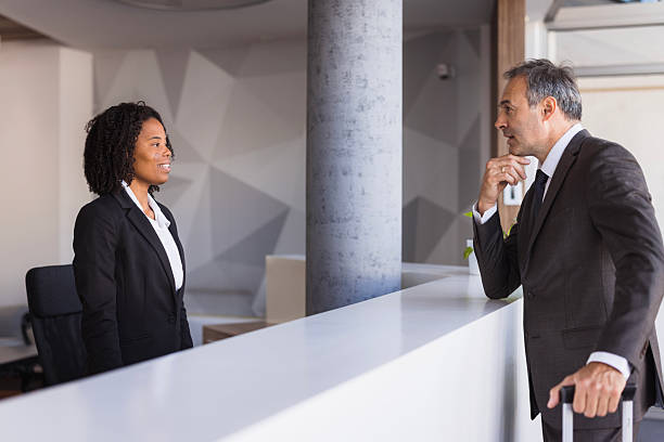 Businessman is asking information to receptionist at the hotel