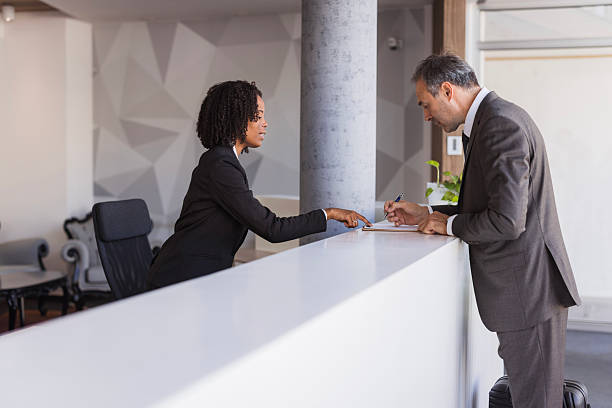 istock Businessman signing document at hotel reception desk 2236090242