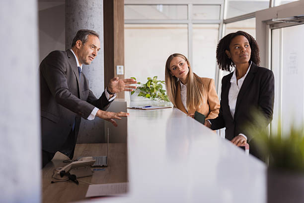 Businesspeople having a discussion at the reception desk in a modern office