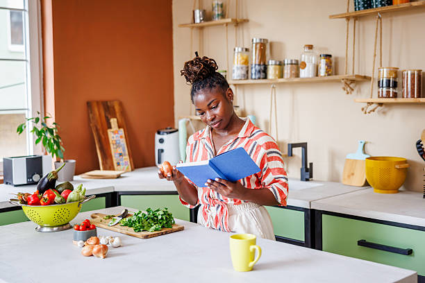 istock Beautiful Young Lady Searching for Healthy Recipe in Notebook 2236091542