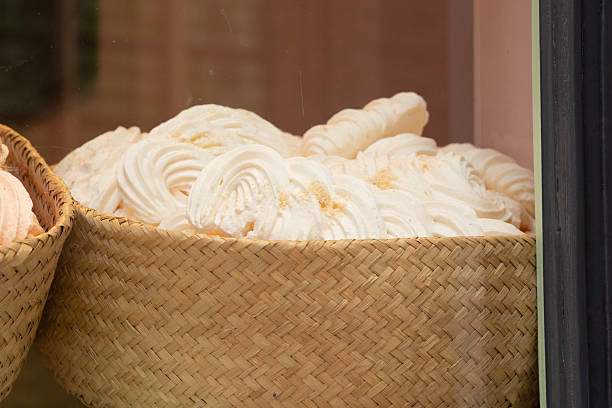 August 28, 2025, Bruges, Belgium — A wicker basket full of white marshmallow swirls dusted with sugar powder.