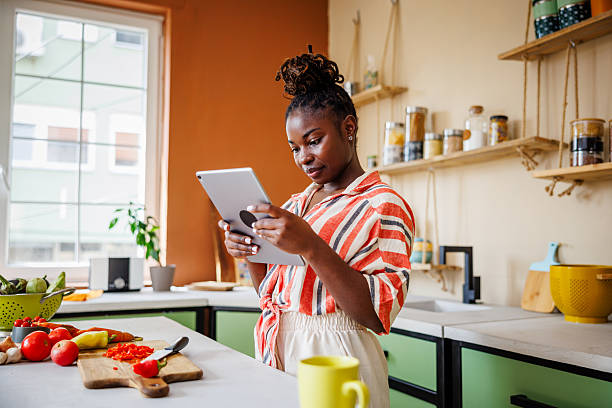 istock Beautiful Black Woman Using Digital Tablet While Preparing Food 2236091862