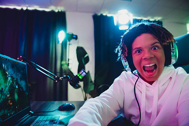A young gamer enthusiastically streaming while gaming by neon lights creating vivid ambiance