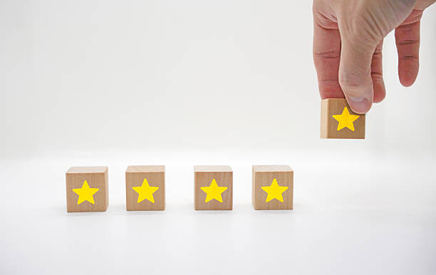 istock Hand Adding Fifth Star to Rating Blocks 2236095689