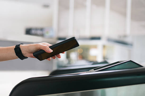 istock Person using a smartphone for contactless payment at a train station gate. 2236096664