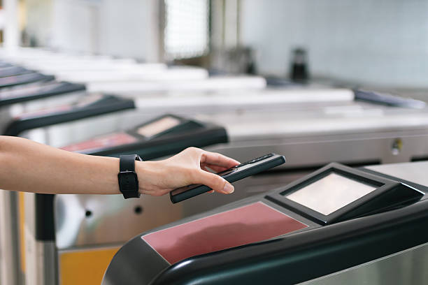 istock Person using a smartphone for contactless payment at a train station gate. 2236096668