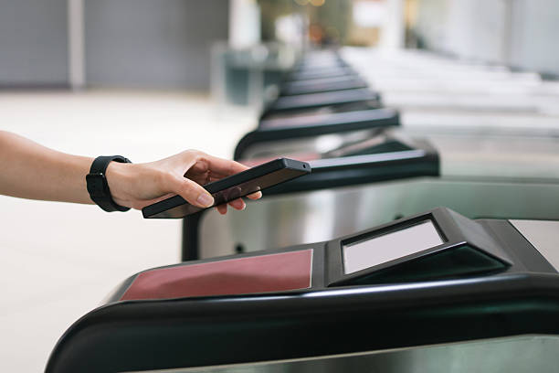 istock Person using a smartphone for contactless payment at a train station gate. 2236096673