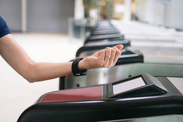 istock Person using a smartwatch for NFC contactless payment at a subway station gate. 2236096678