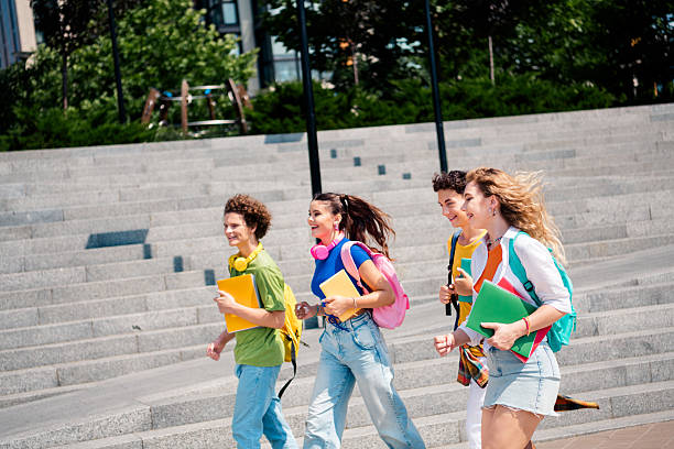 istock Group of college students walking outdoors on campus, enjoying sunny day 2236098677