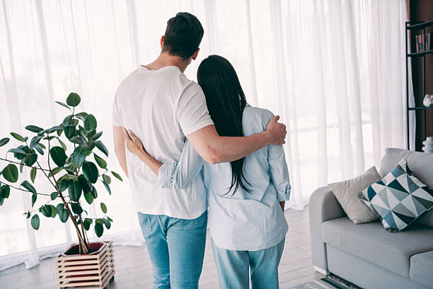istock Young affectionate couple sharing an embrace in a cozy living room setting, highlighting concepts of love, bonding, and interior coziness 2236099752