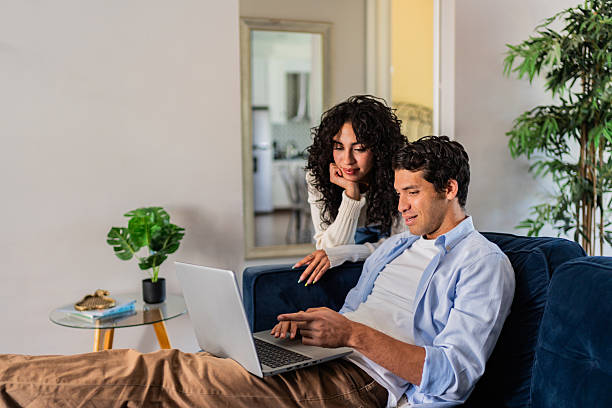 istock Young woman arriving and taking to husband while he using laptop at home 2236099938