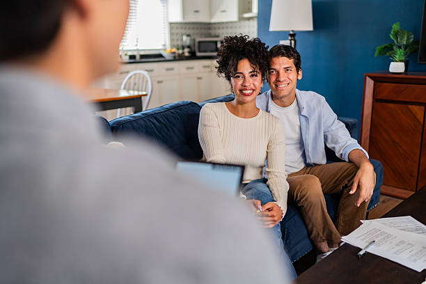 istock Young couple talking to financial advisor at home 2236100084