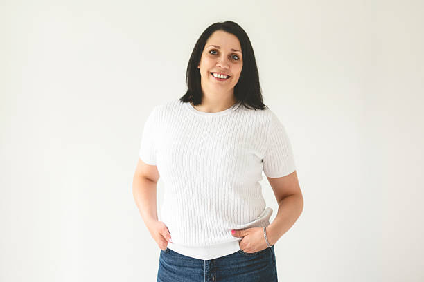istock Real and authentic mature woman looking at camera and smiling while standing against white background 2236101569