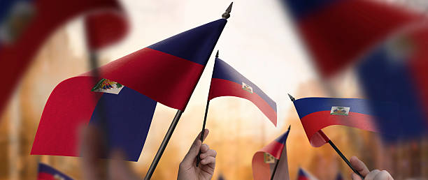 istock Haiti flags in their hands on a blurred urban background 2236101798