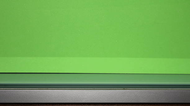 Empty metal and glass table top with green copy space background, for displaying the advertised product.
