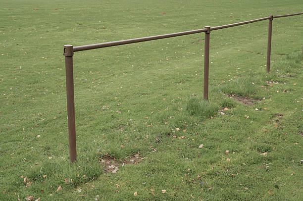 Metal railing boundary defining a sports field or park area