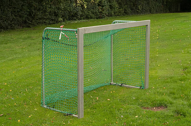 istock Soccer goal net standing on green grass field 2236104001