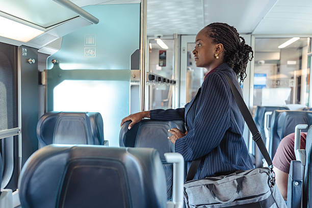 istock Woman standing in modern train interior holding onto a support rail 2236104136