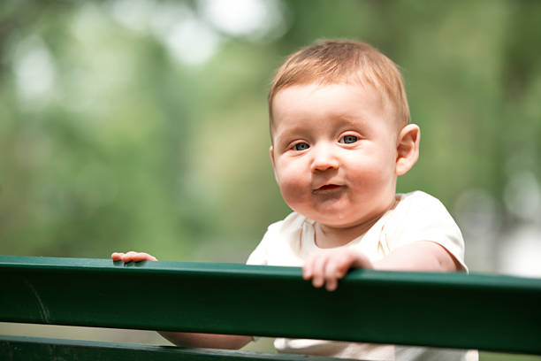 A little six months baby boy outside on meadow