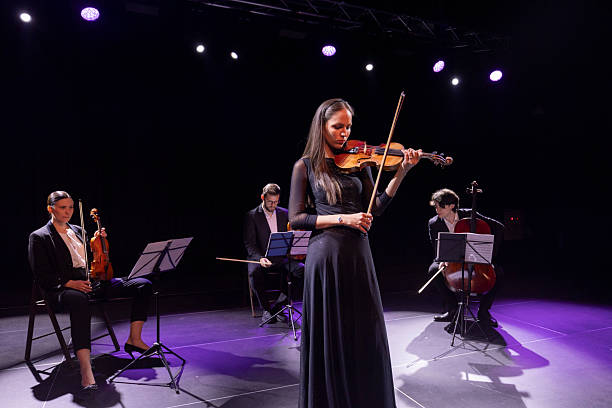 istock Elegant Female Violinist Performing with a String Quartet Under Spotlight 2236105652