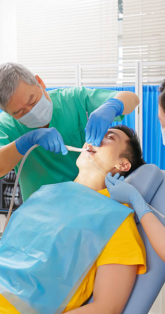 istock elderly dentist cleans teeth of young patient 2236107411